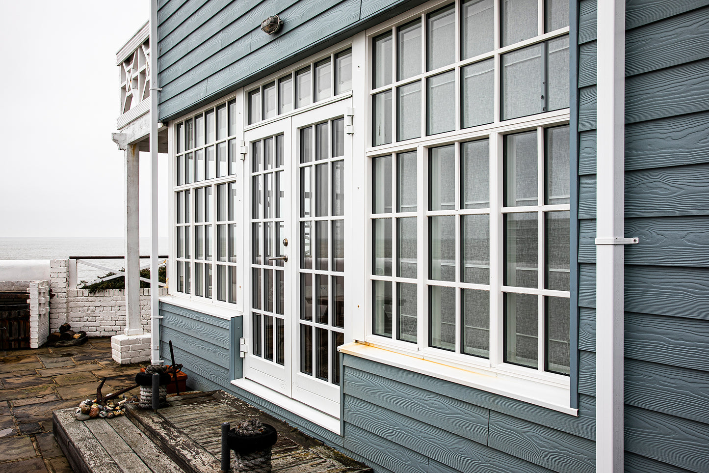 External view of a double-glazed, aluminum-clad framed door in a seafront renovation.