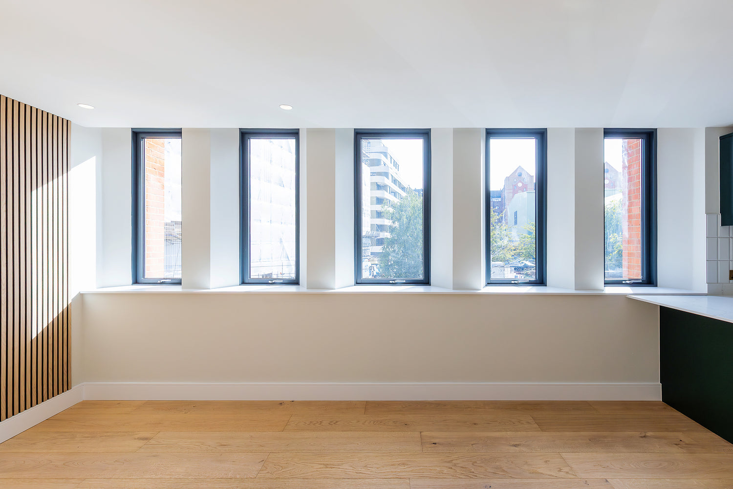 Internal view of a double-glazed, aluminum-clad outward-opening window in a revitalized residential development.