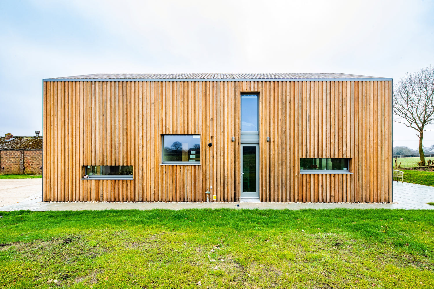 Modern house with wooden facade and triple-glazed windows in a rural setting
