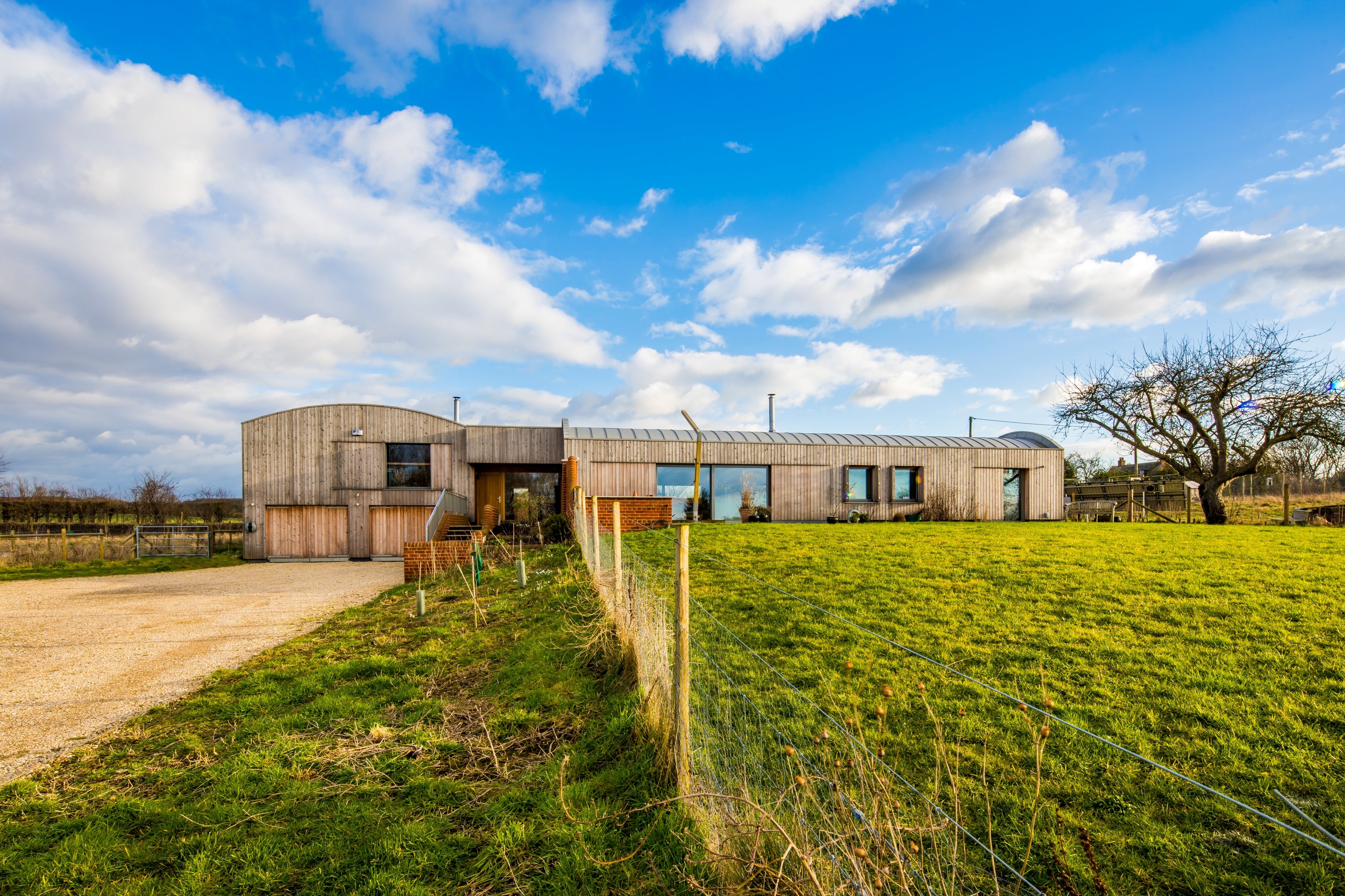 Modern triple-glazed house in a rural setting with a clear blue sky