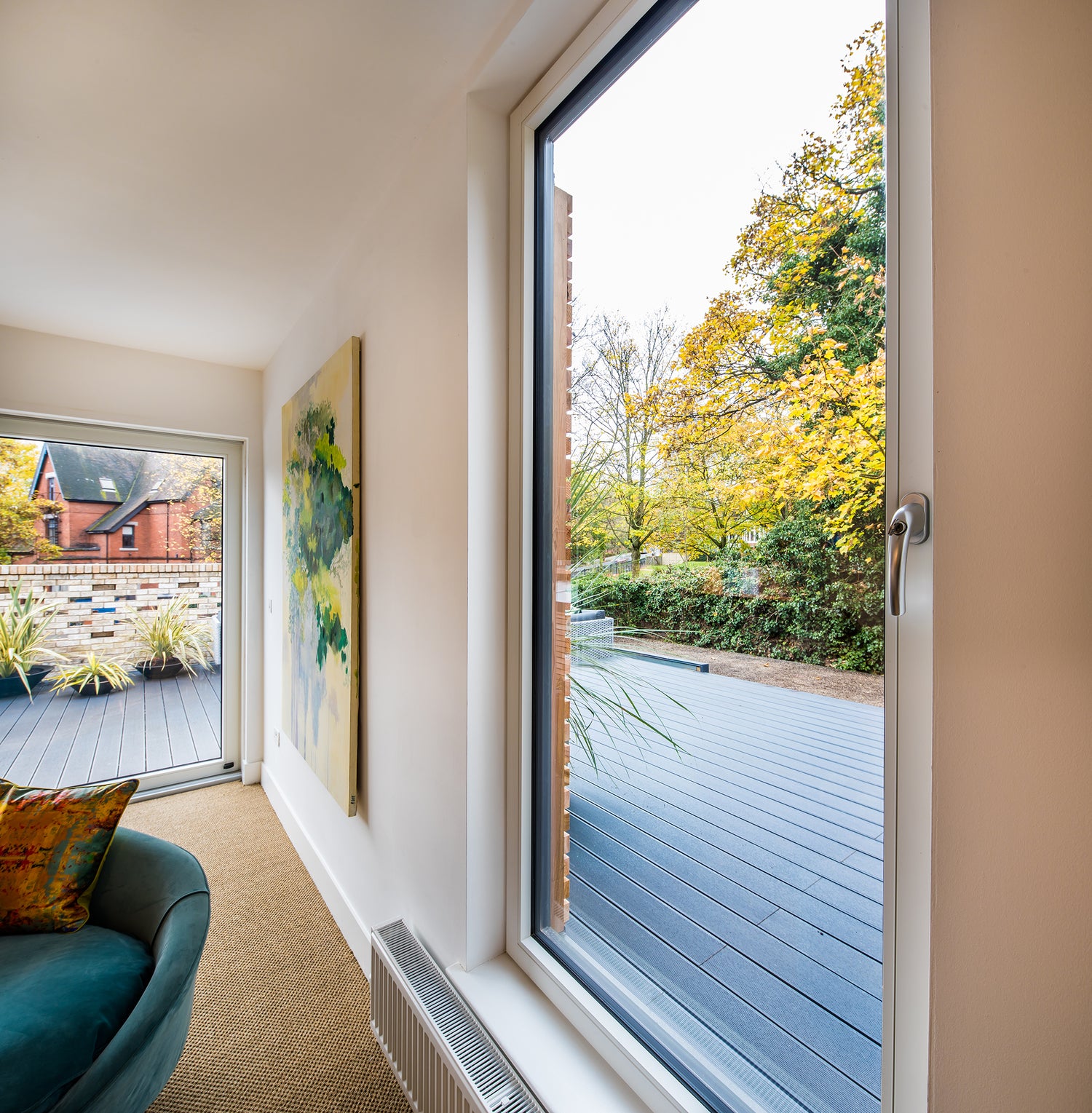 Modern interior with a large triple-glazed window showing a garden view
