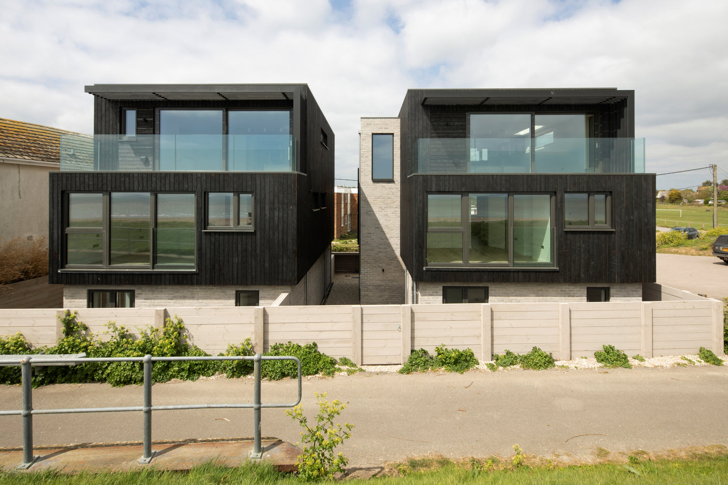 Modern house with black exterior and triple-glazed glass windows on a clear day