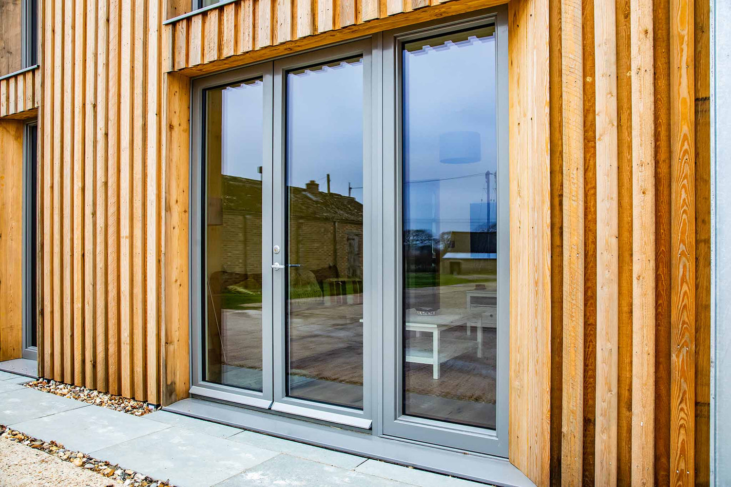 Wooden house exterior with large triple-glazed glass sliding doors