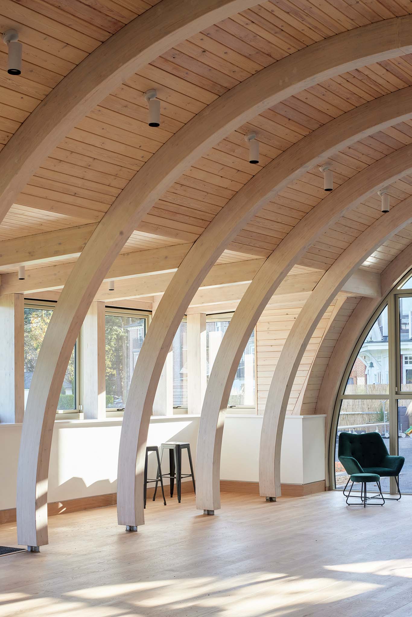 Modern interior with curved wooden ceiling and large double-glazed windows