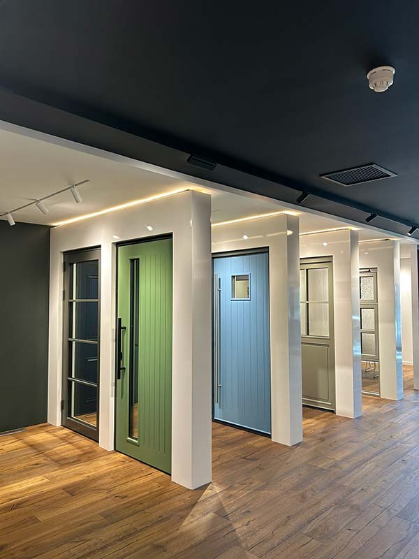 Modern interior with triple-glazed green and blue doors on a wooden floor.