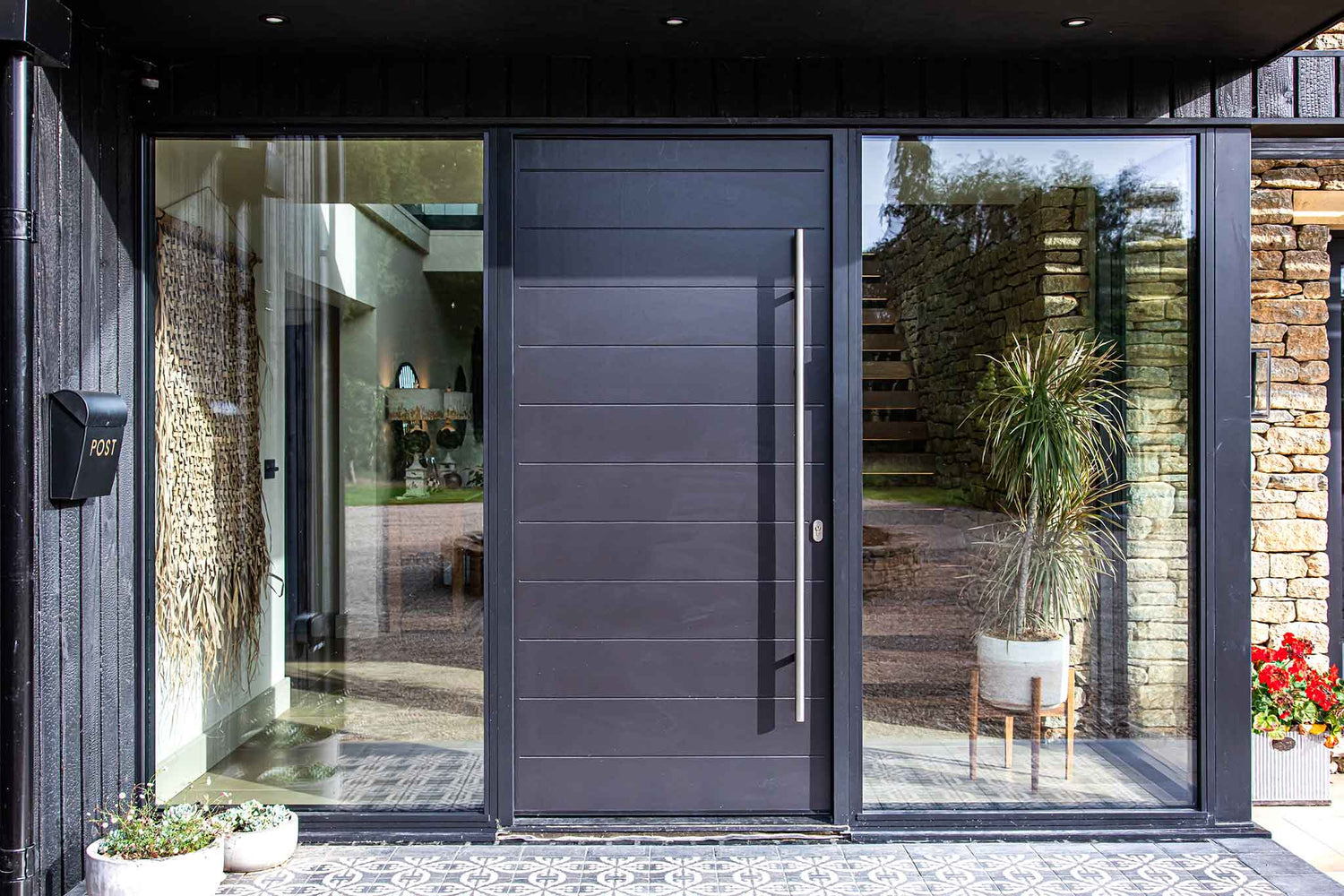 Modern black door with triple-glazed glass panels in a house entrance