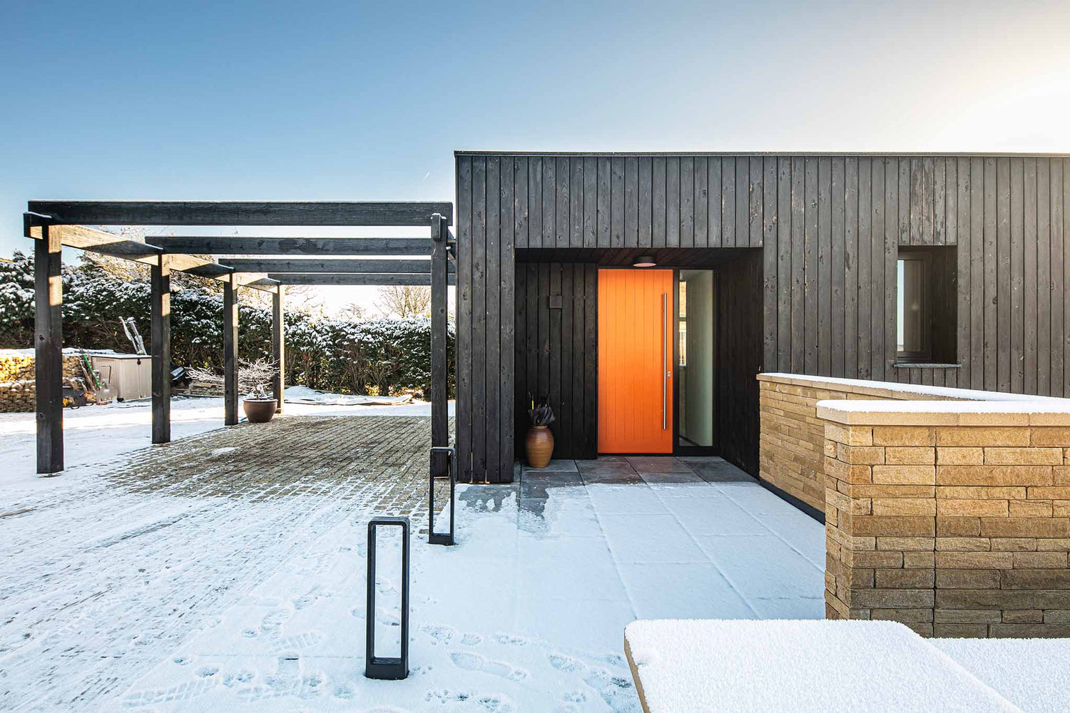 Modern house exterior with a snowy landscape and triple-glazed sidelights