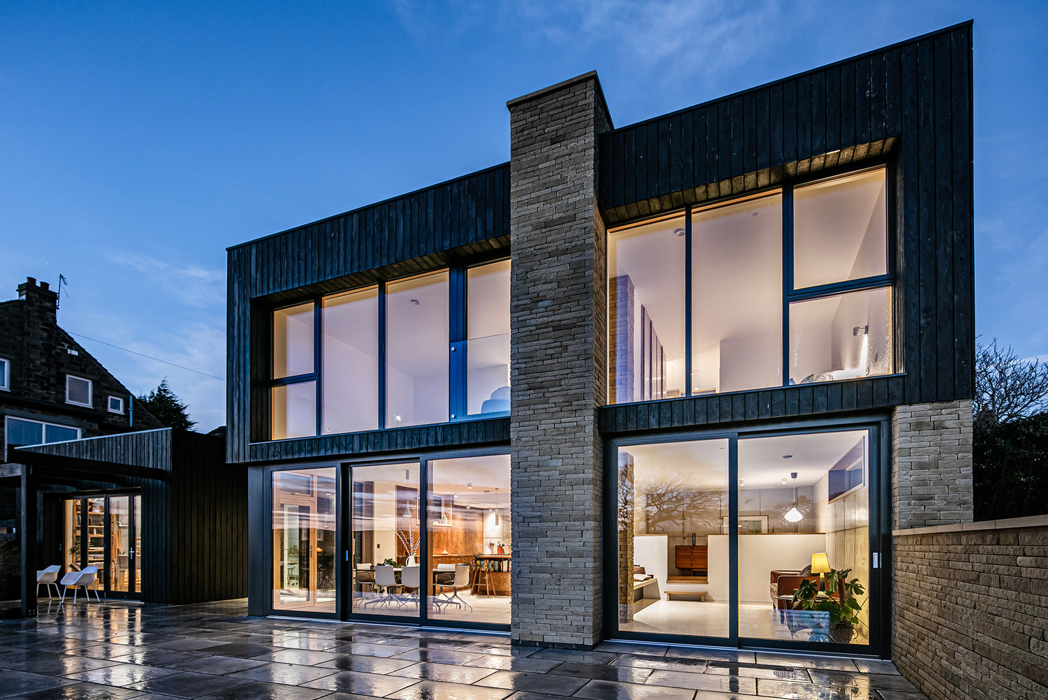 Modern house with large glass triple-glazed windows at dusk