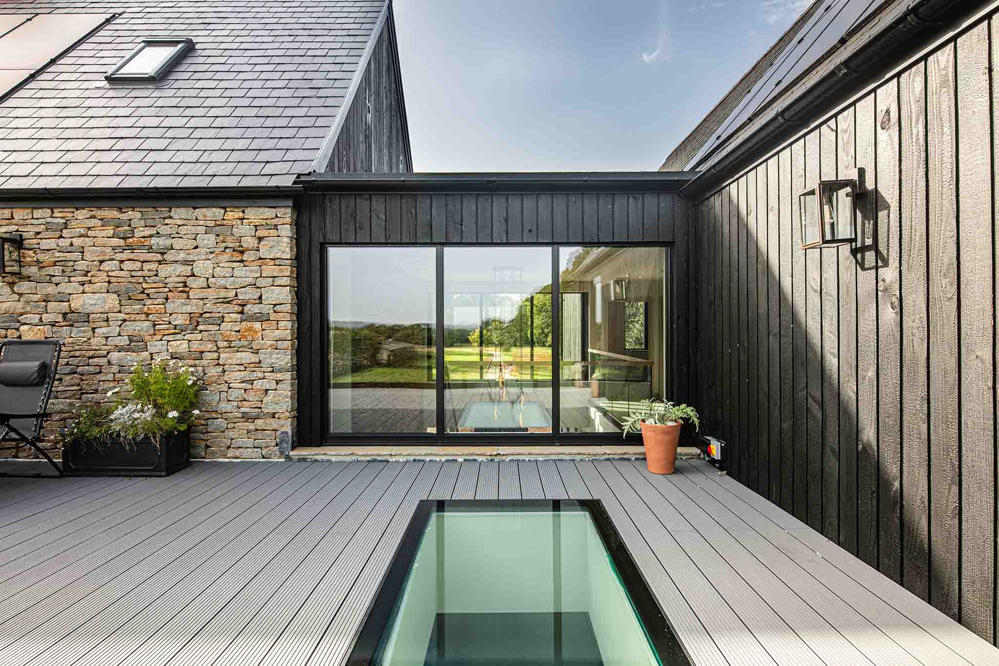 Modern house with triple-glazed windows, a pool area featuring stone and wooden walls.