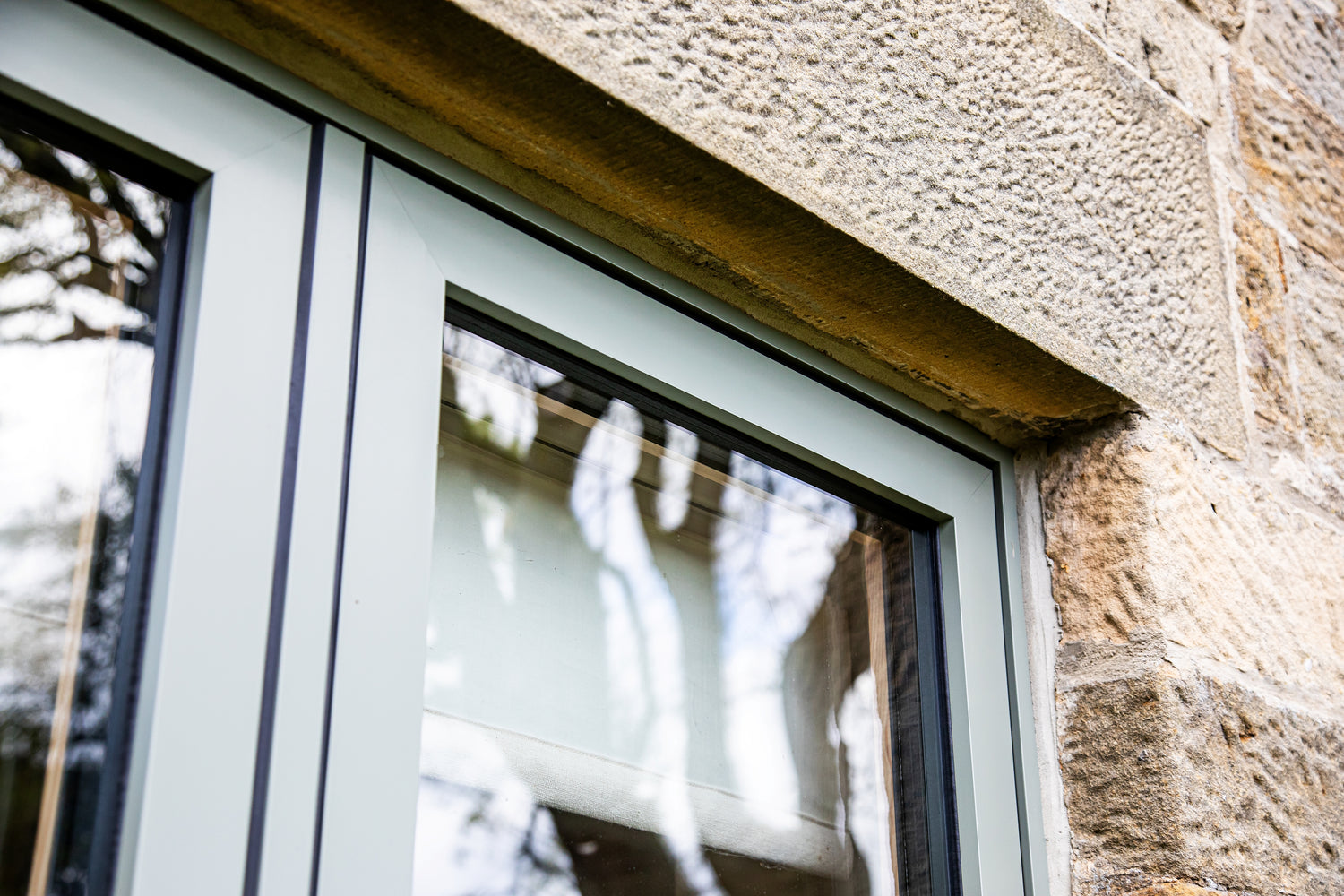 Window frame with triple-glazed glass and stone wall background