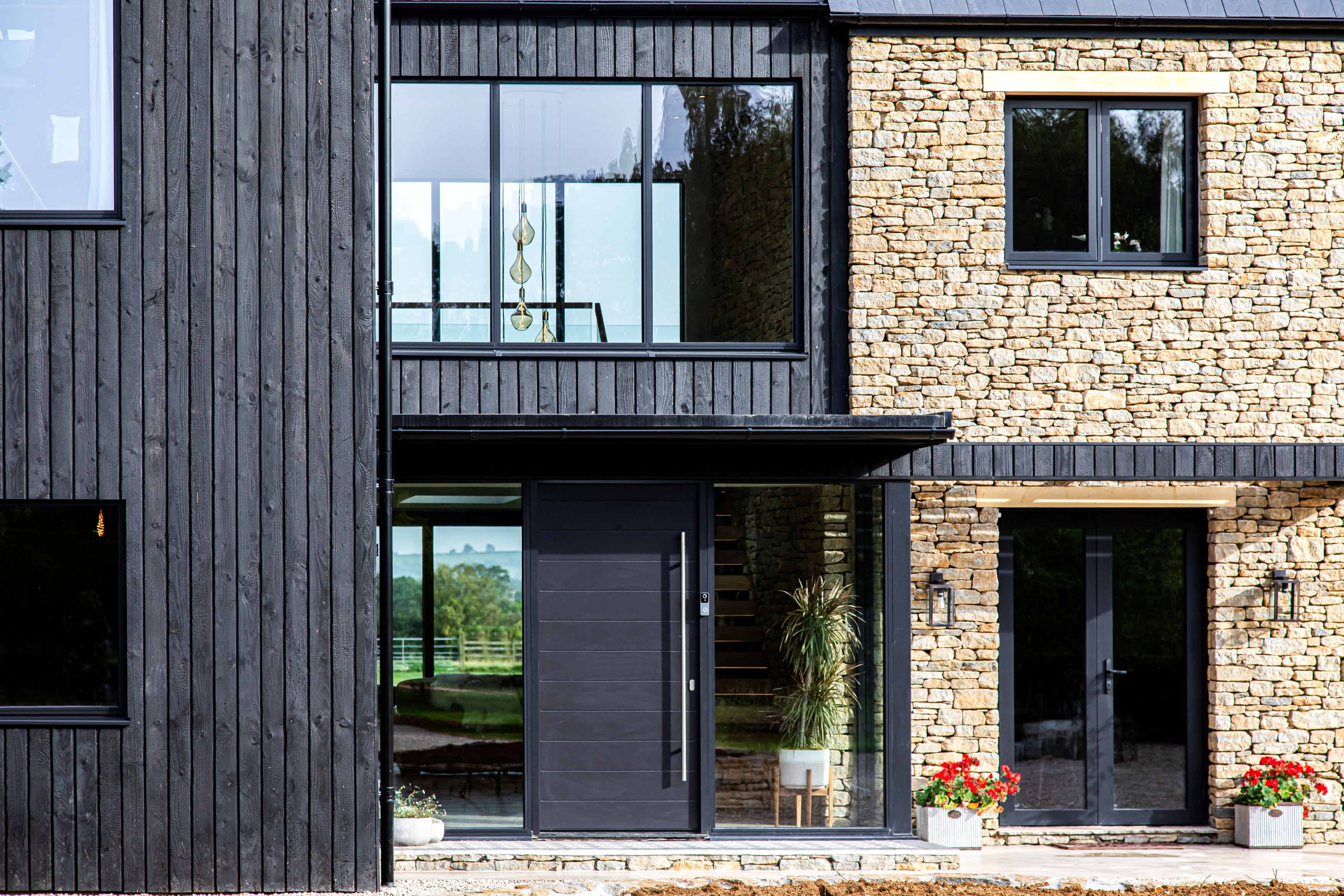 Modern house with triple-glazed windows, black and stone exterior