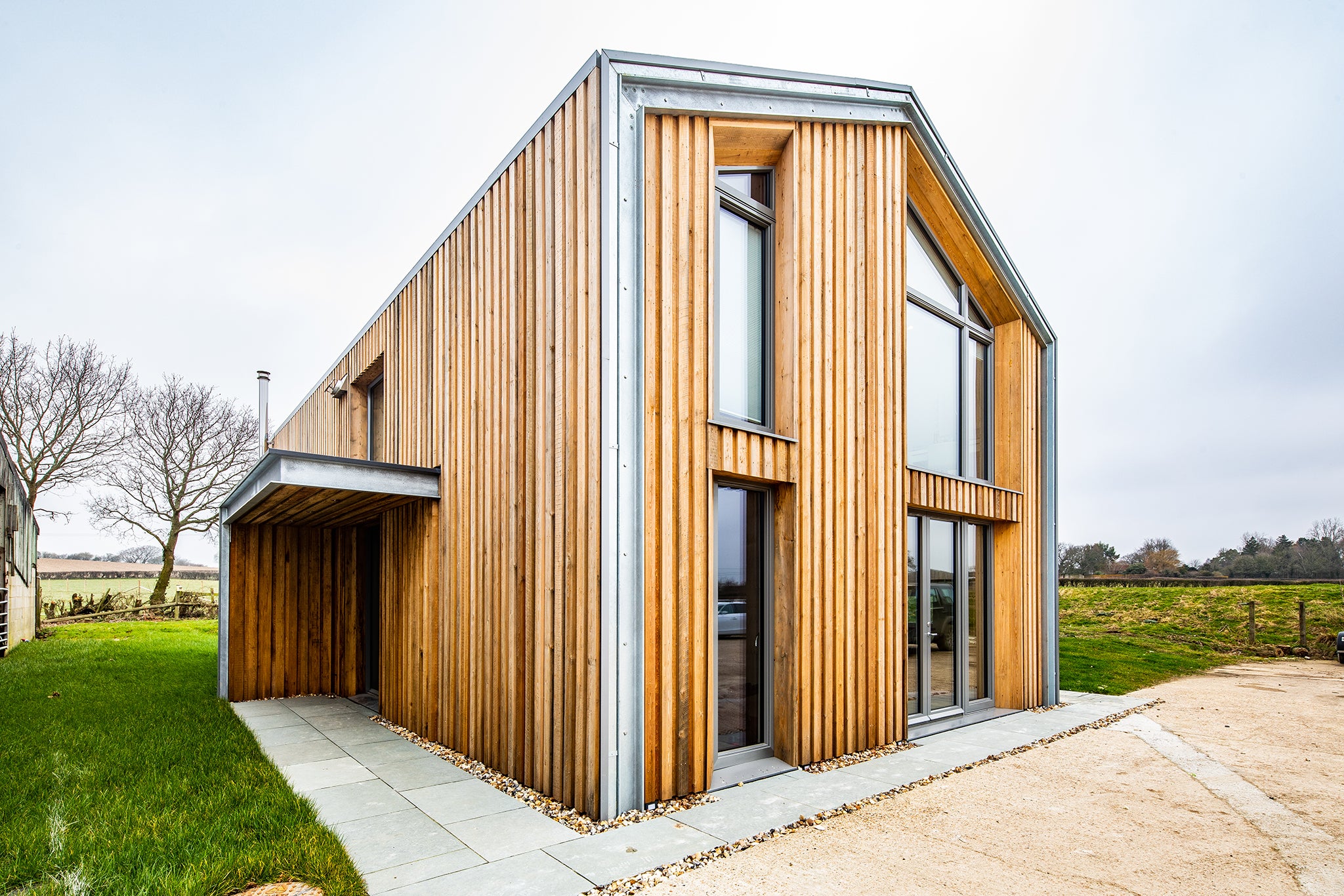 Exterior view of a triple-glazed, aluminum-clad angled window in an agricultural passive house.
