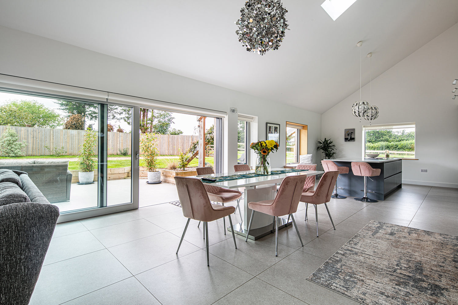 Internal view of an open, triple-glazed, aluminum-clad sliding door in a timber-frame new build.