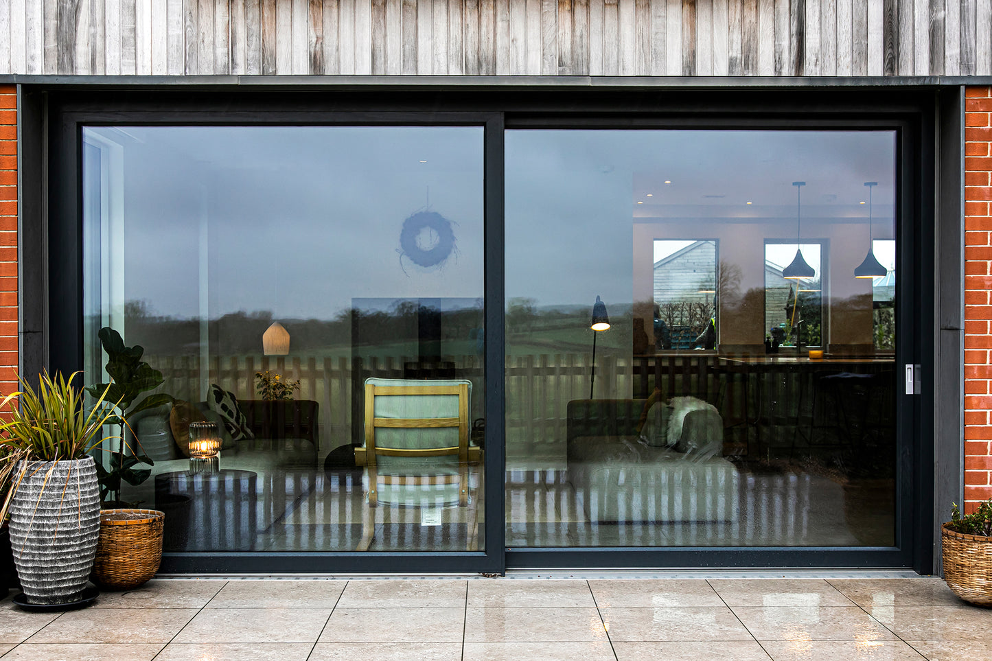External view of a triple-glazed, aluminum-clad sliding door in an eco-style passive house.