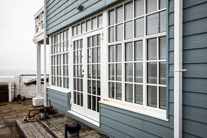 External view of a double-glazed, aluminum-clad framed door in a seafront renovation.