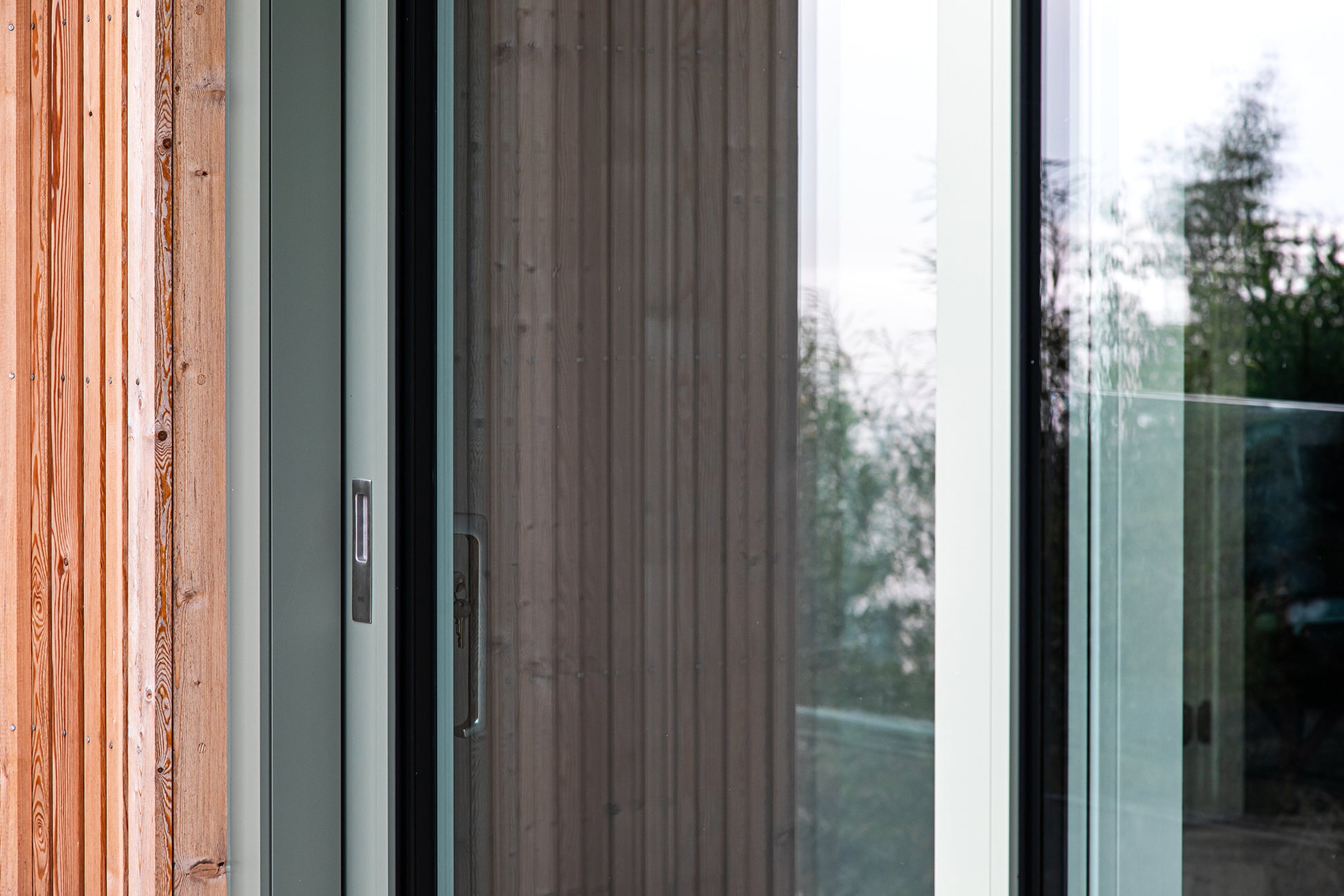 External detail view of a triple-glazed, aluminum-clad handle in a seaside passive home.