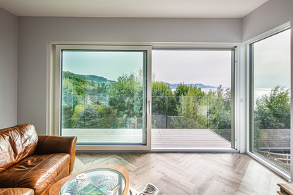 Internal view of an open, triple-glazed, aluminum-clad sliding door in a seaside passive home.