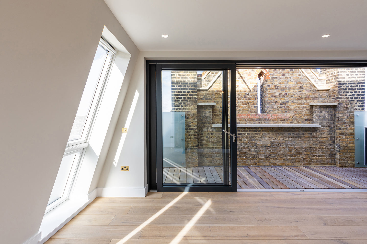 Internal view of an open, double-glazed, aluminum-clad sliding door in a revitalized residential development.