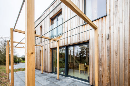 External view of a triple-glazed, aluminum-clad sliding door in a rural passive house.