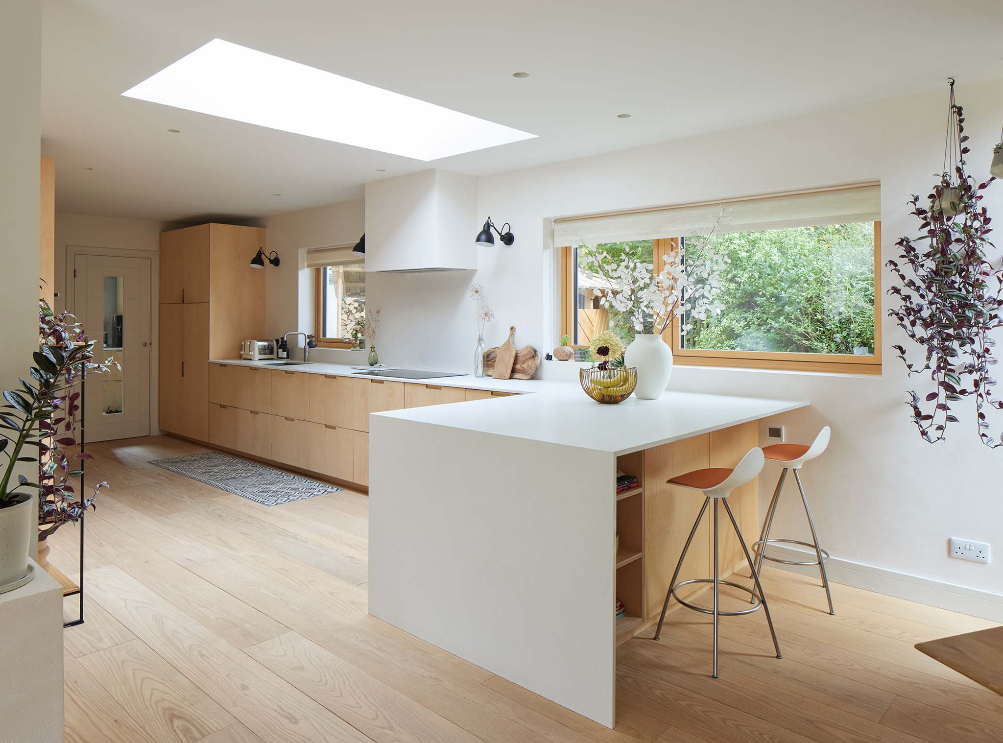 Modern kitchen with white island, wooden cabinets, and large triple-glazed window