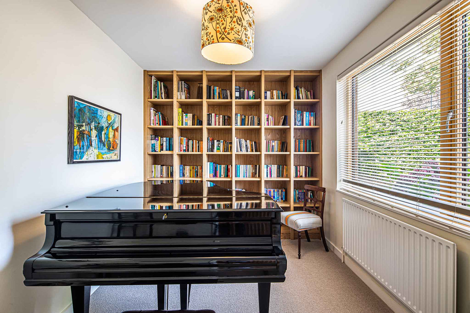 Piano in a room with bookshelves and a double-glazed window