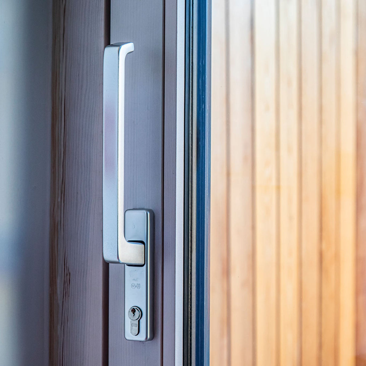 Close-up of a modern door handle and lock on a wooden door.