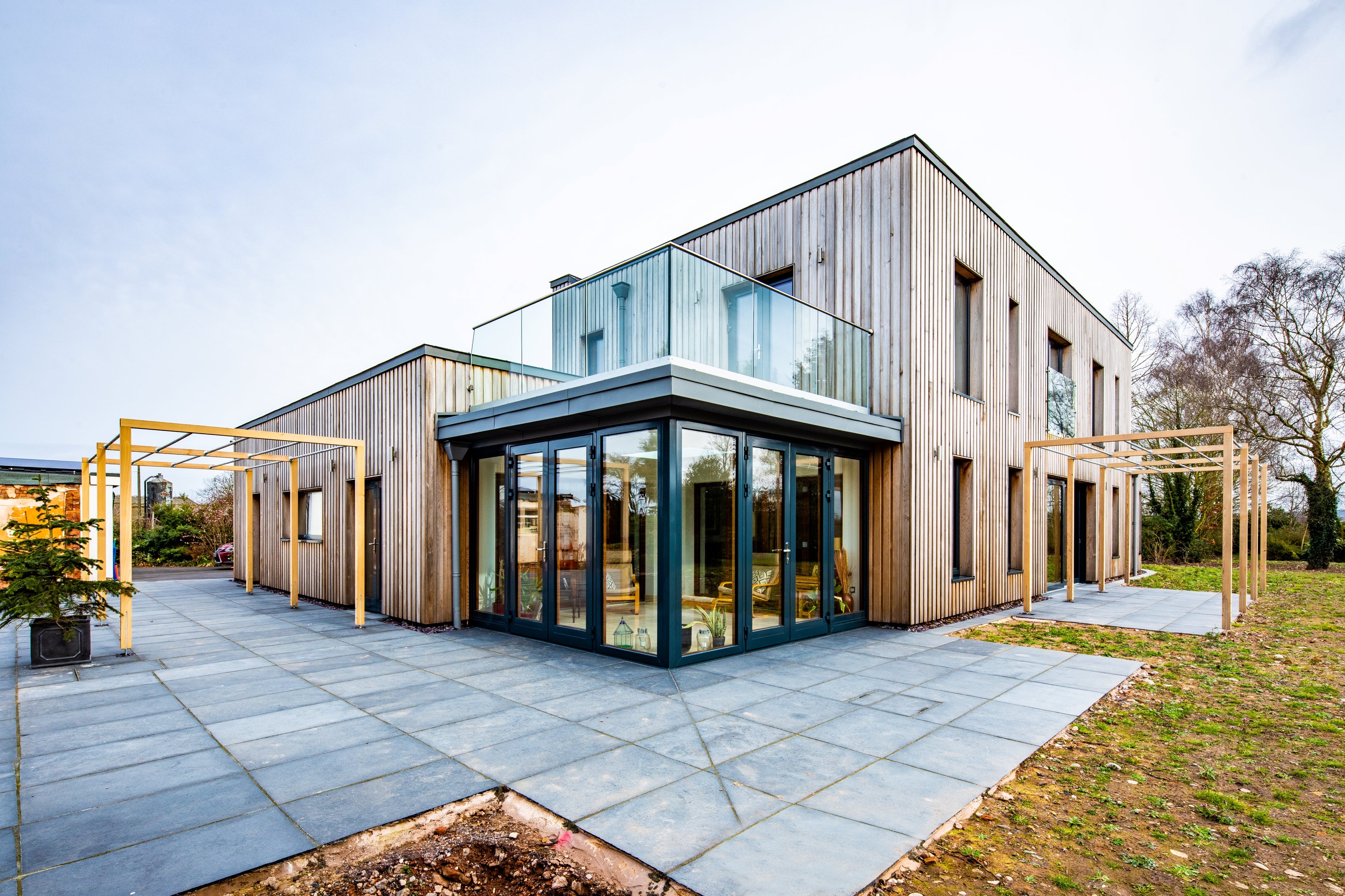 Modern house with triple-glazed glass facade and wooden exterior on a clear day