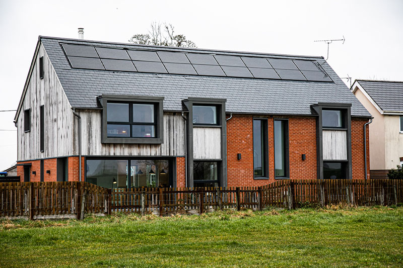 Image of a brick and timber clad passive house with Norrsken P41A windows in anthracite grey